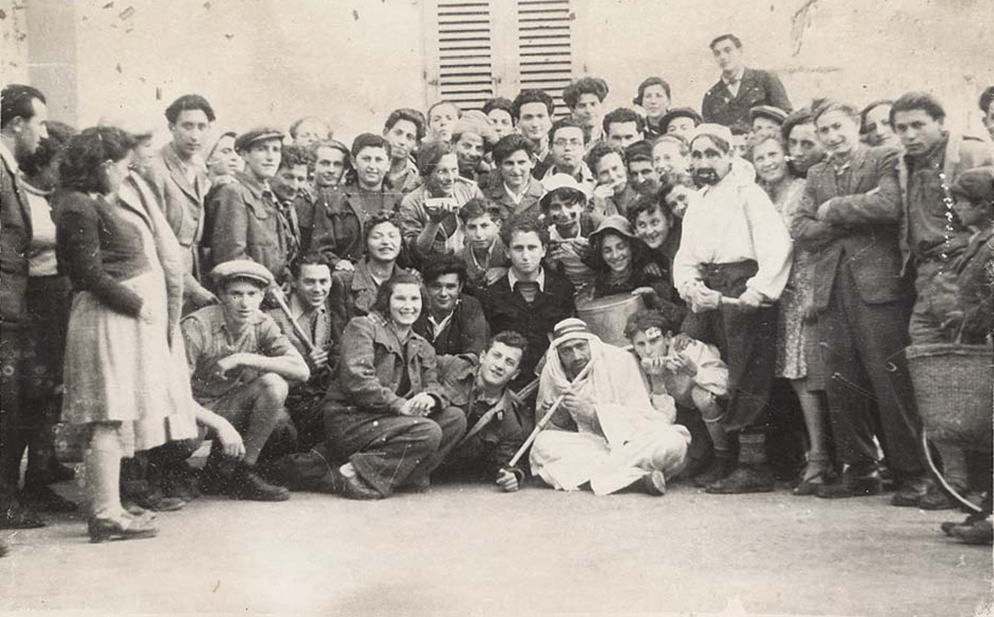 תמונה קבוצתית של חברי "קיבוץ  ארלוזורוב" שהשתתפו במשתה פורים שנערך במחנה העקורים "מרינה די לויצ'ה", איטליה