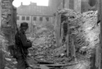 A Waffen SS soldier next to a destroyed house in the Warsaw Ghetto, 1943