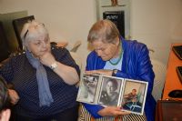 Shalhevet Sara Ziv showing a picture of her  mother to her newly found cousin Tatiana Zuckerman 