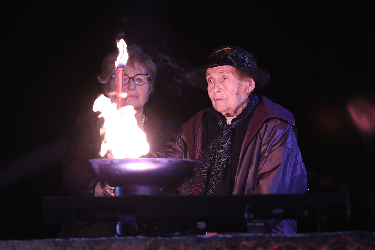 Die Holocaustüberlebende Manya Bigunov entzündet eine der sechs Flammen bei der Zeremonie