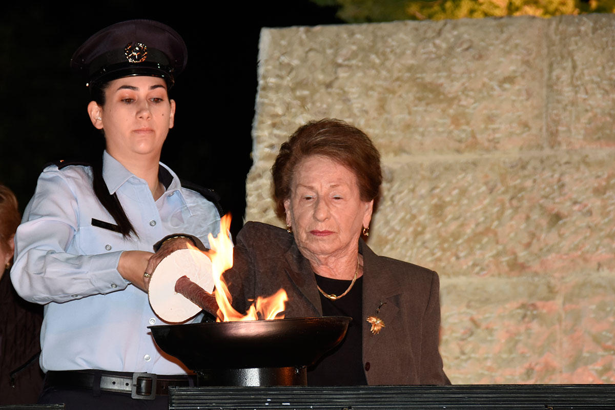 La sobreviviente del Holocausto Sara Fishman encendiendo una de las seis antorchas durante la ceremonia
