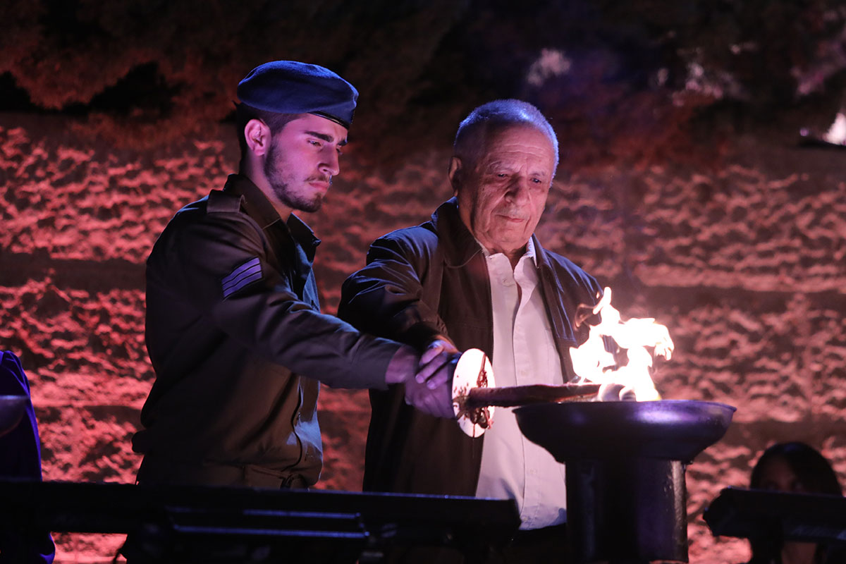 Der Holocaustüberlebende Yossi Chen entzündet eine der sechs Flammen bei der Zeremonie