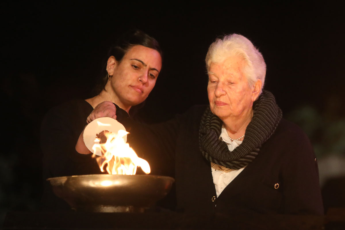 La sobreviviente del Holocausto Rebecca Elizur encendiendo una de las seis antorchas durante la ceremonia