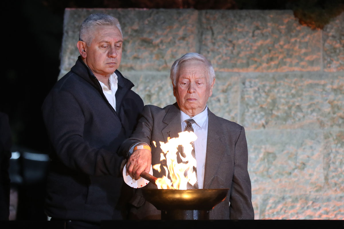 El sobreviviente del Holocausto Efim Gimelshtein encendiendo una de las seis antorchas durante la ceremonia