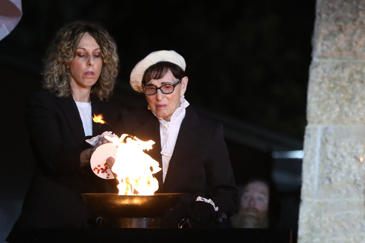 La sobreviviente del Holocausto Malka Rendel encendiendo una de las seis antorchas durante la ceremonia