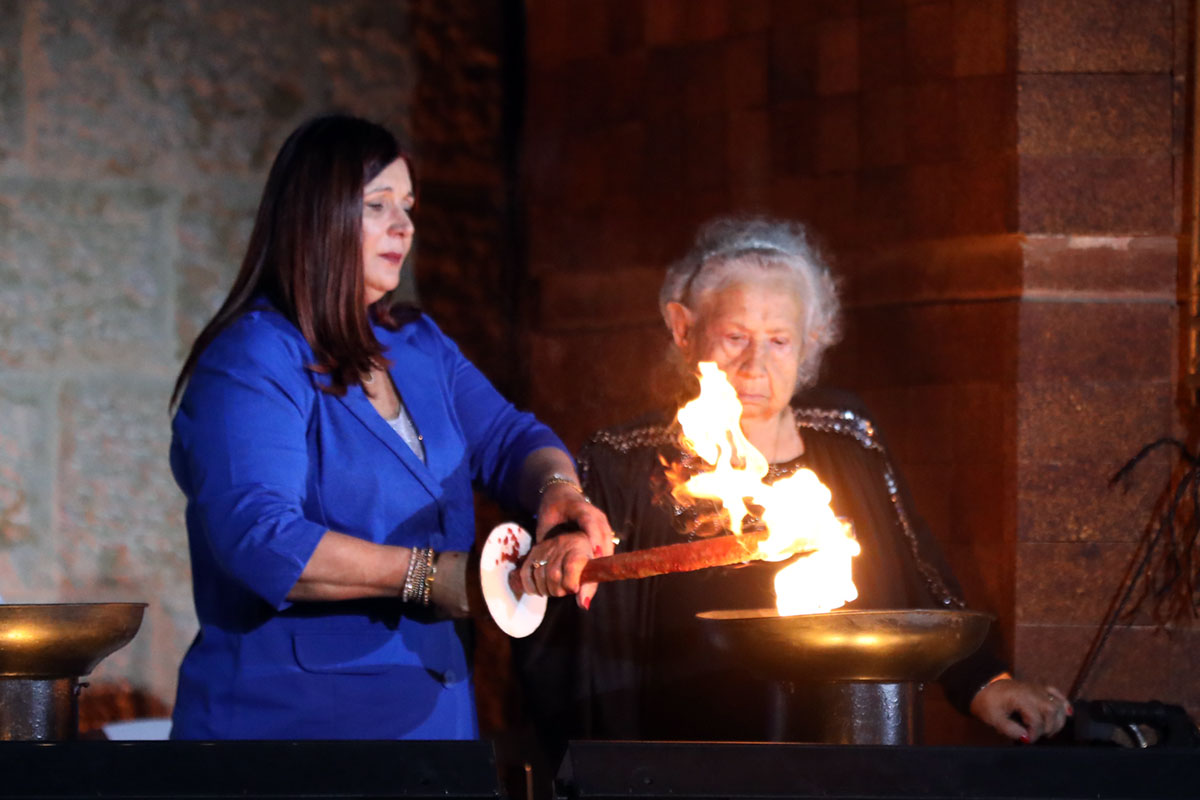 La sobreviviente del Holocausto Tova Gutstein encendiendo una de las seis antorchas durante la ceremonia