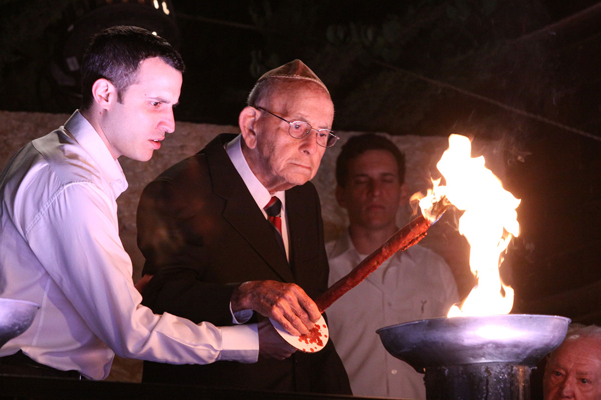 El sobreviviente del Holocausto Tzvi Mijaeli encendiendo una de las seis antorchas durante la ceremonia