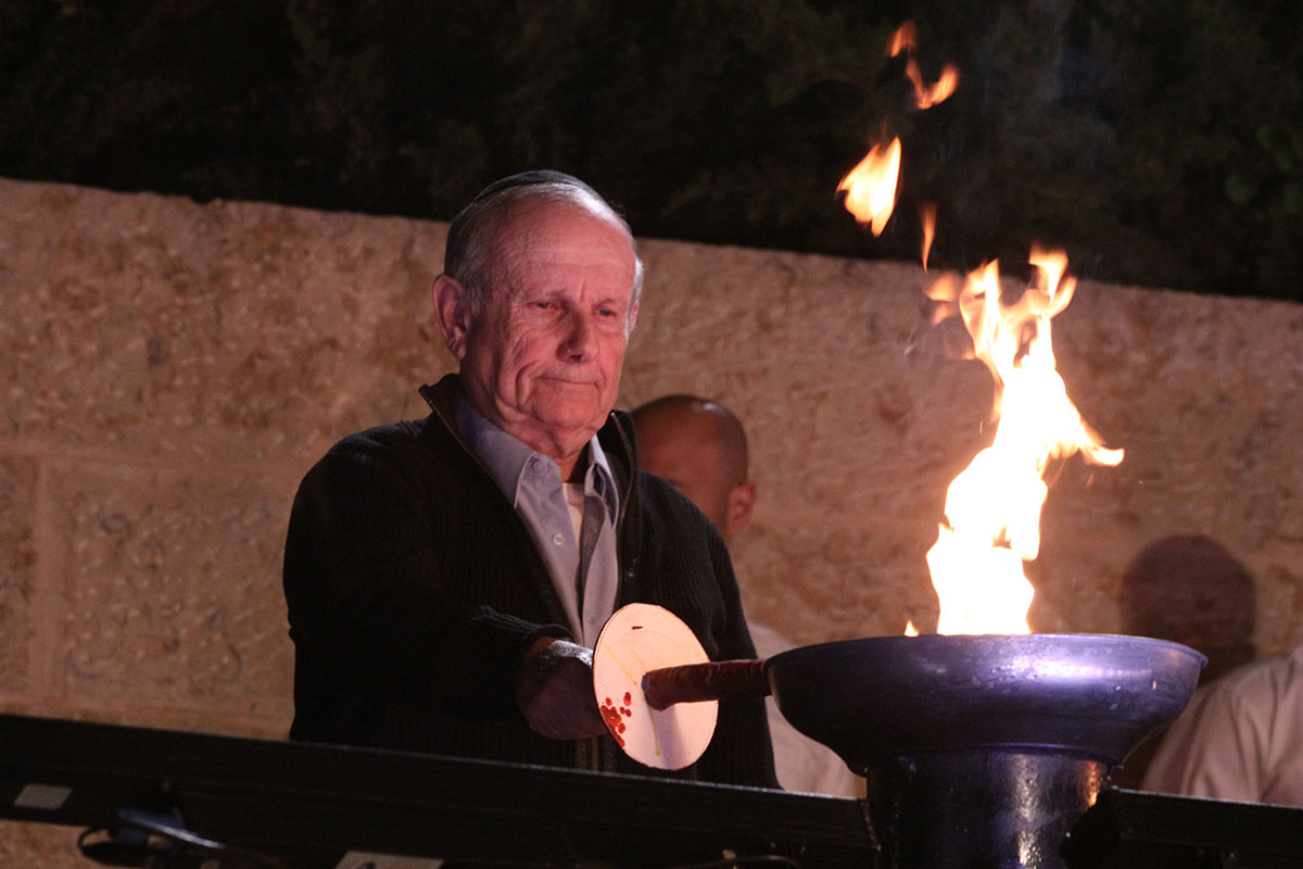 El sobreviviente del Holocausto Jaim Herzl encendiendo una de las seis antorchas durante la ceremonia