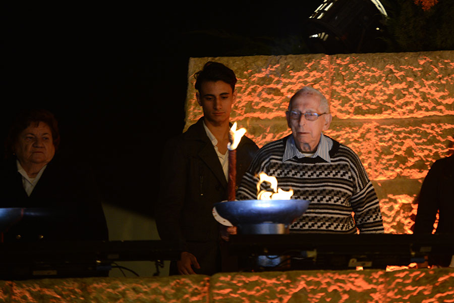 El sobreviviente del Holocausto Eggi Lewysohn encendiendo una de las seis antorchas durante la ceremonia