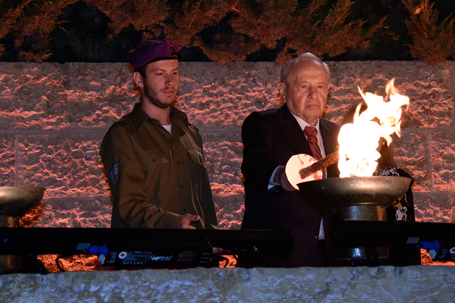 El sobreviviente del Holocausto Jehosua Hesel Fried encendiendo una de las seis antorchas durante la ceremonia
