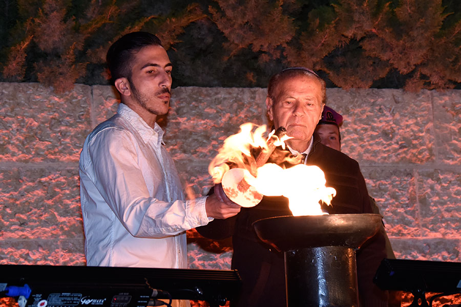 El sobreviviente del Holocausto Joseph Lab encendiendo una de las seis antorchas durante la ceremonia