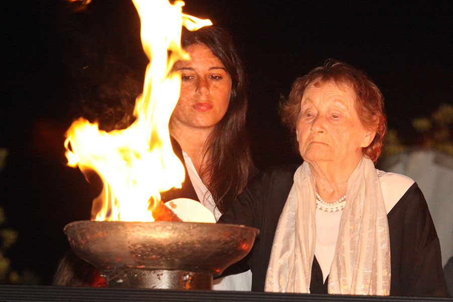 La sobreviviente del Holocausto  Lonia Rozenhoch encendiendo una de las seis antorchas durante la ceremonia