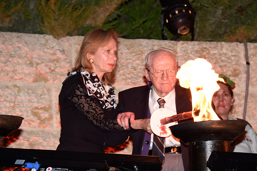 El sobreviviente del Holocausto Robert Tomashof encendiendo una de las seis antorchas durante la ceremonia