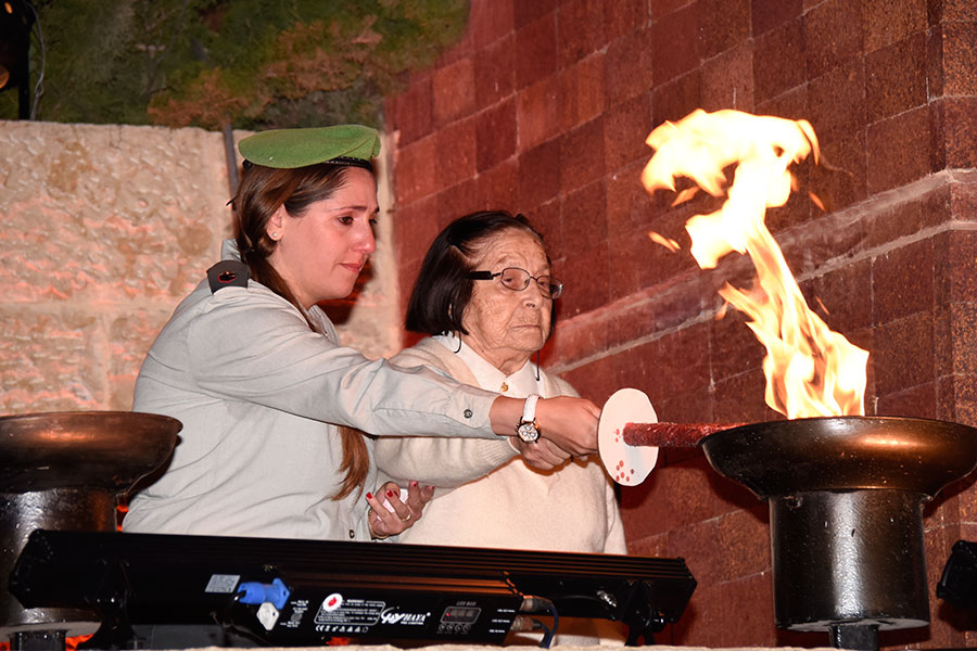 La sobreviviente del Holocausto Sara Kain encendiendo una de las seis antorchas durante la ceremonia