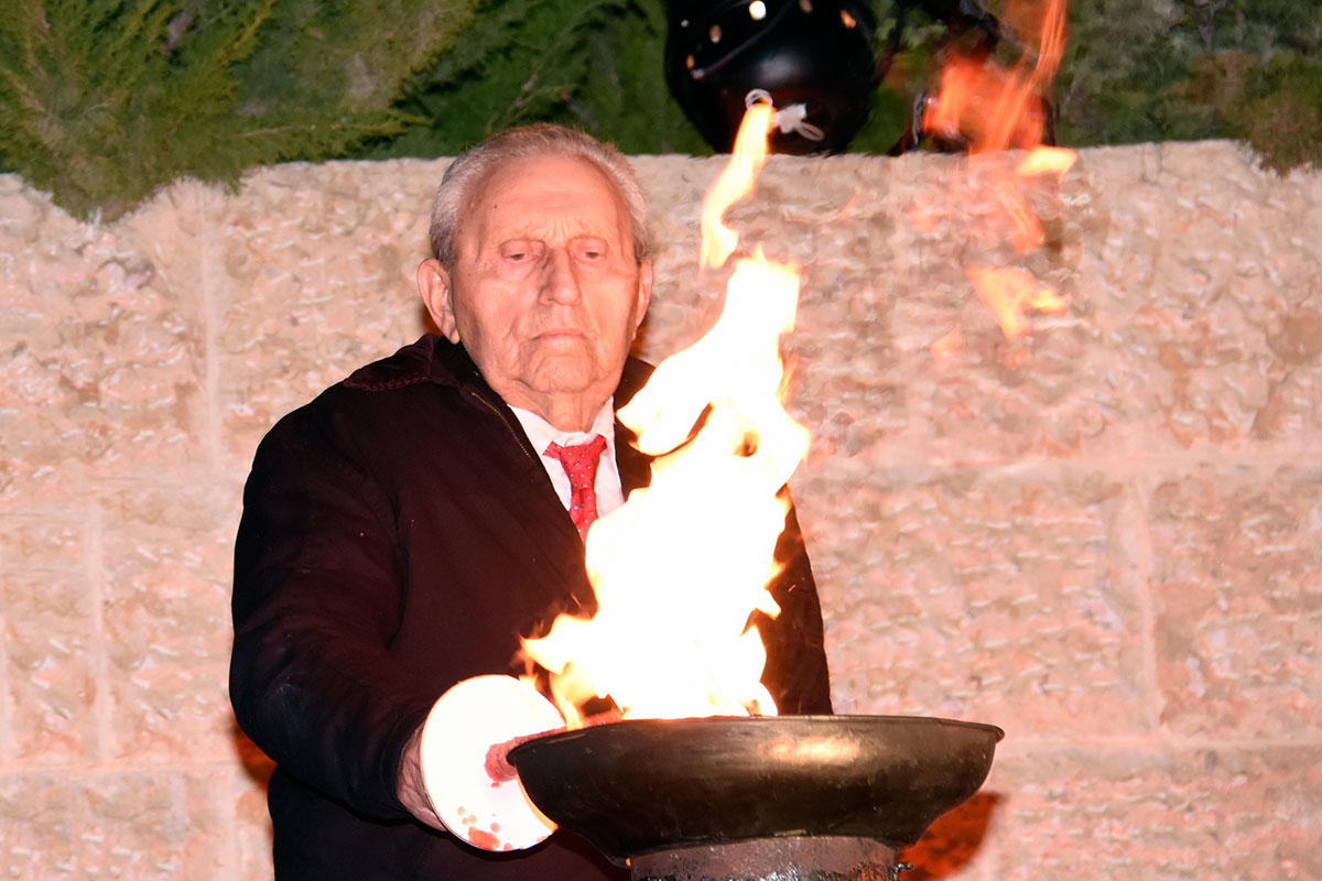 El sobreviviente del Holocausto Moshe Jakubowitz encendiendo una de las seis antorchas durante la ceremonia