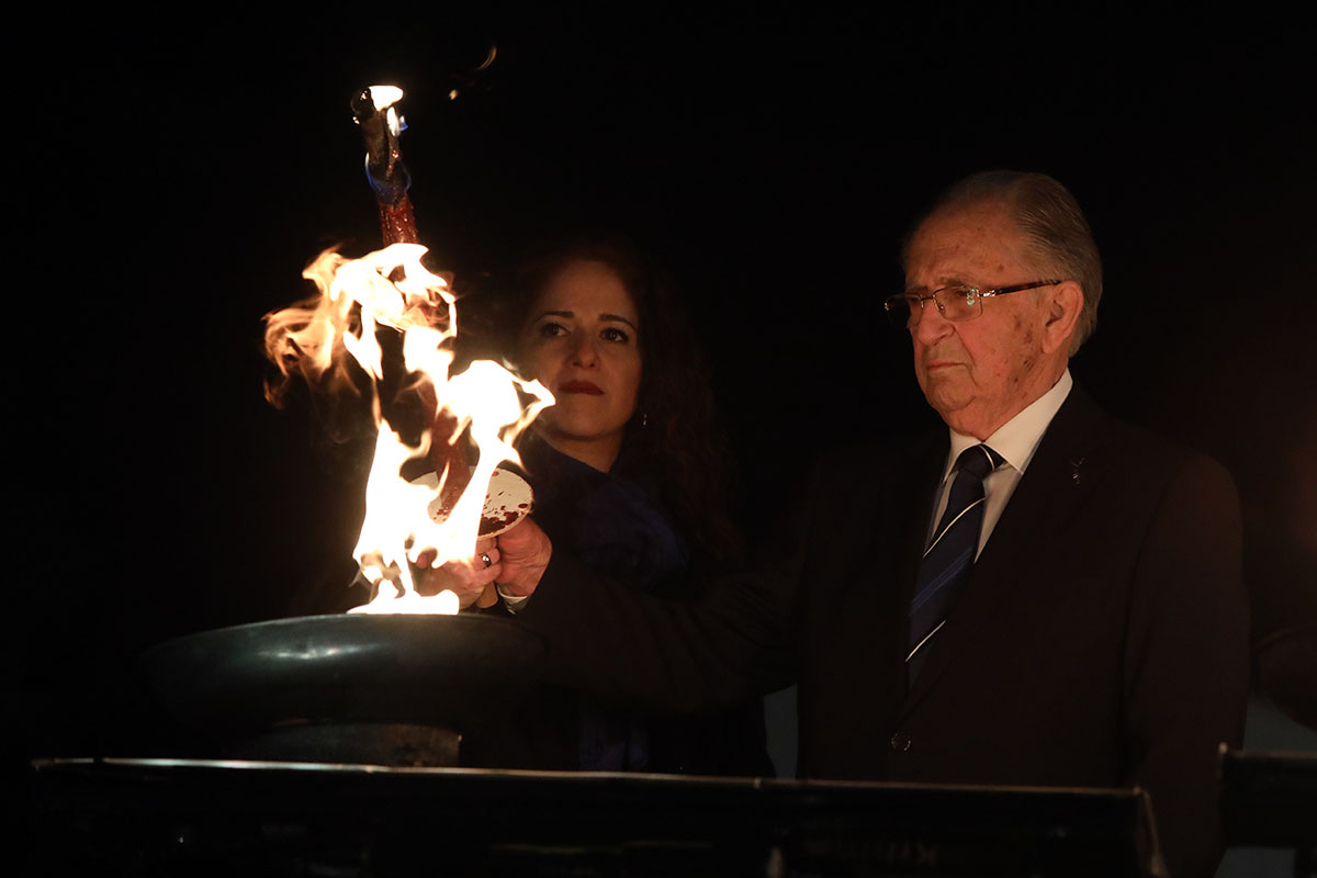 El sobreviviente del Holocausto Abba Naor encendiendo una de las seis antorchas durante la ceremonia