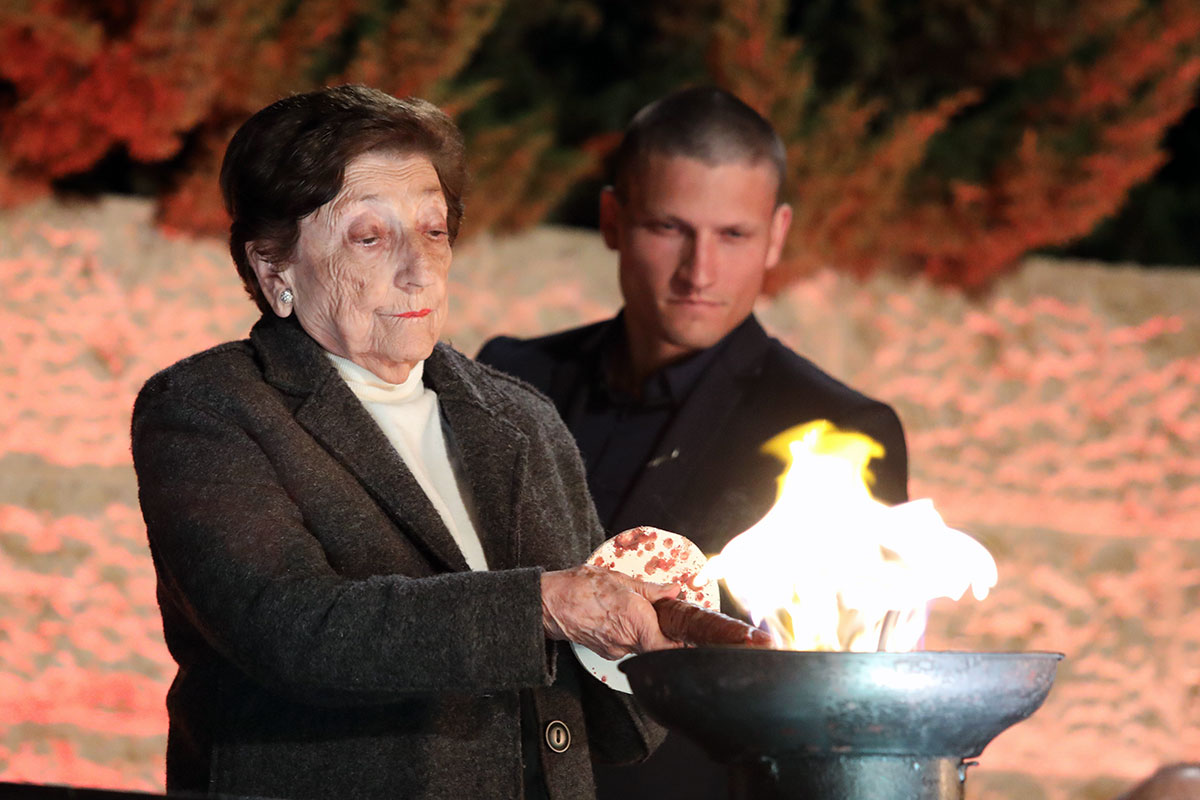 La sobreviviente del Holocausto Dr. Thea Friedman encendiendo una de las seis antorchas durante la ceremonia