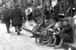 Jóvenes sentados en una acera del gueto de Varsovia.
Archivo fotográfico de Yad Vashem.