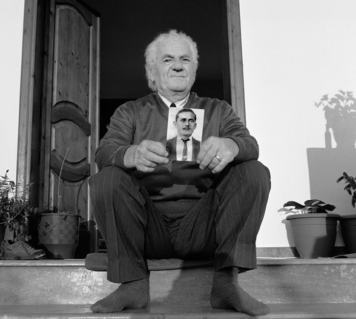 Sazan Hoxha sosteniendo una foto de su padre, Nuro Hoxha