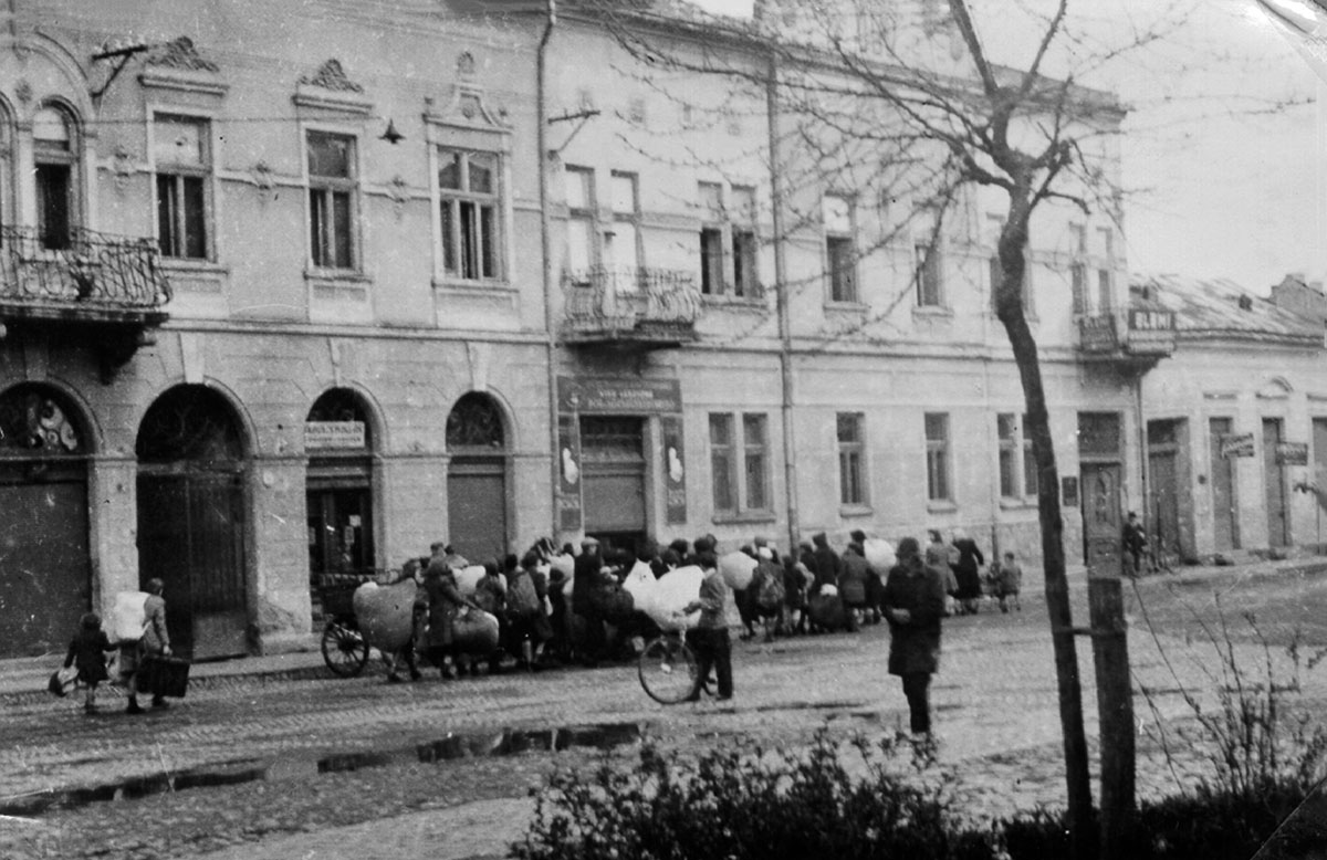 גירוש יהודי מונקאץ'. היהודים עוברים עם צרורותיהם ברח' מיהאי (Mihaly), מול התאטרון הגדול. הם הובלו לבית חרושת ללבנים ומשם גורשו