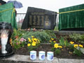 The gravestone with the prisoner numbers alongside two additional memorials which give the names and identities of the murder victims. The photograph was taken moments before the beginning of the unveiling ceremony.