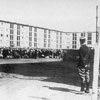 A group of prisoners in the Drancy transit camp, guarded by a French policeman.