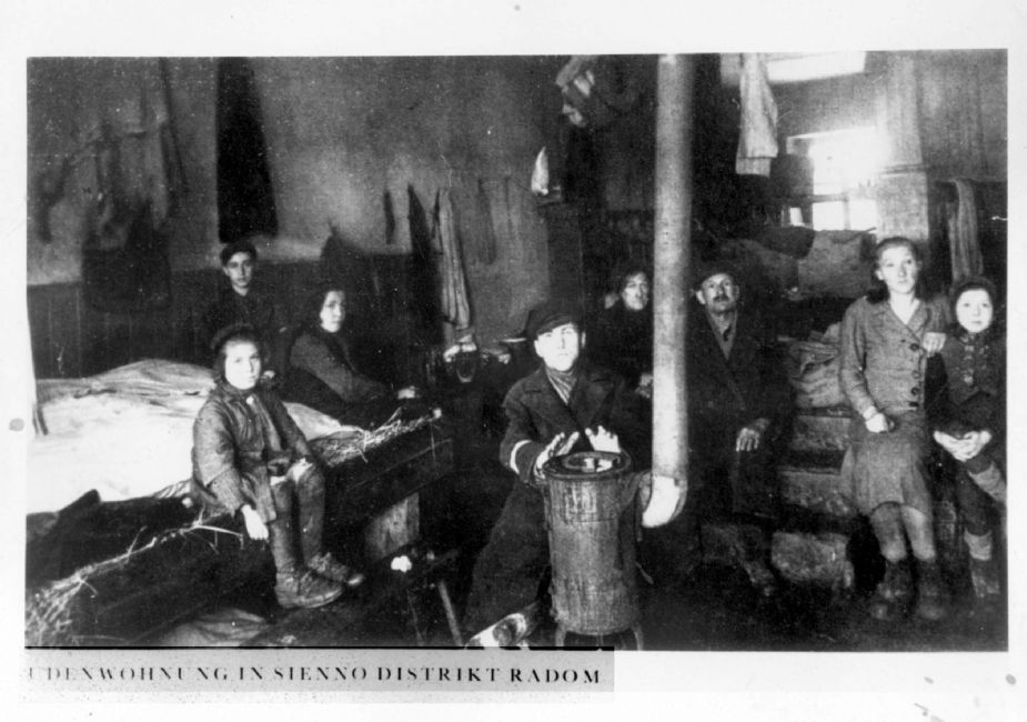 Poland ,Radom, יהודים מתחממים סביב אח בחדר בגטו. ארכיון יד ושם, 1605/1824