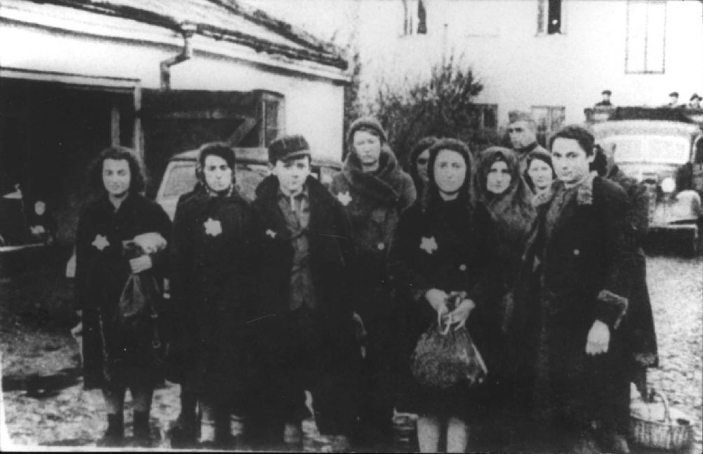 Sieradz, Poland, תצלום של קבוצת יהודים שנעצרו על ידי המשטרה הצבאית באשמה שהם מבריחי שוק שחור .<br>
ארכיון יד ושם, 7244/1
