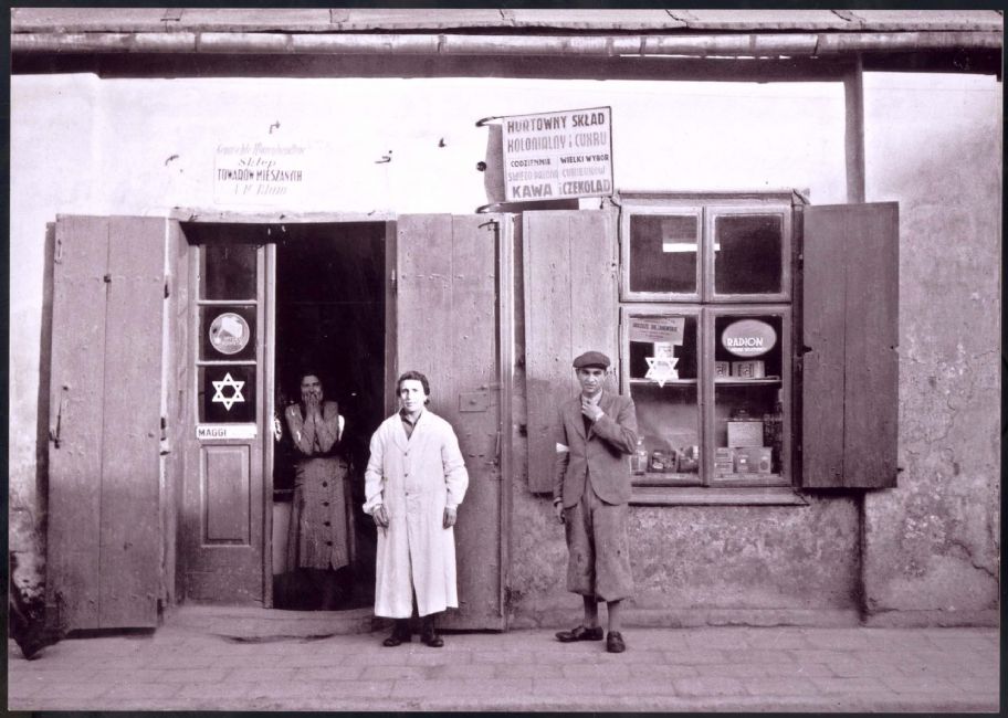 Poland ,Rzeszow, תצלום של גבר יהודי ושתי נשים יהודיות עומדים ליד חנות מסומנת בגטו.<br>
ארכיון יד ושם, 7891/1<br>
