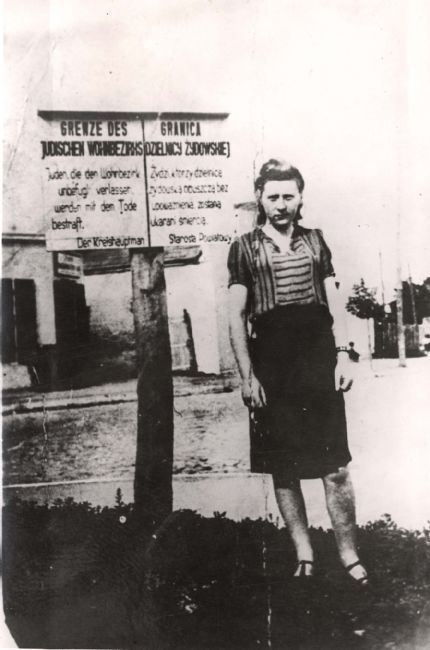 Poland ,Zwolen, אישה עומדת ליד שלט בכניסה לגטו.<br>
ארכיון יד ושם, 56GO8