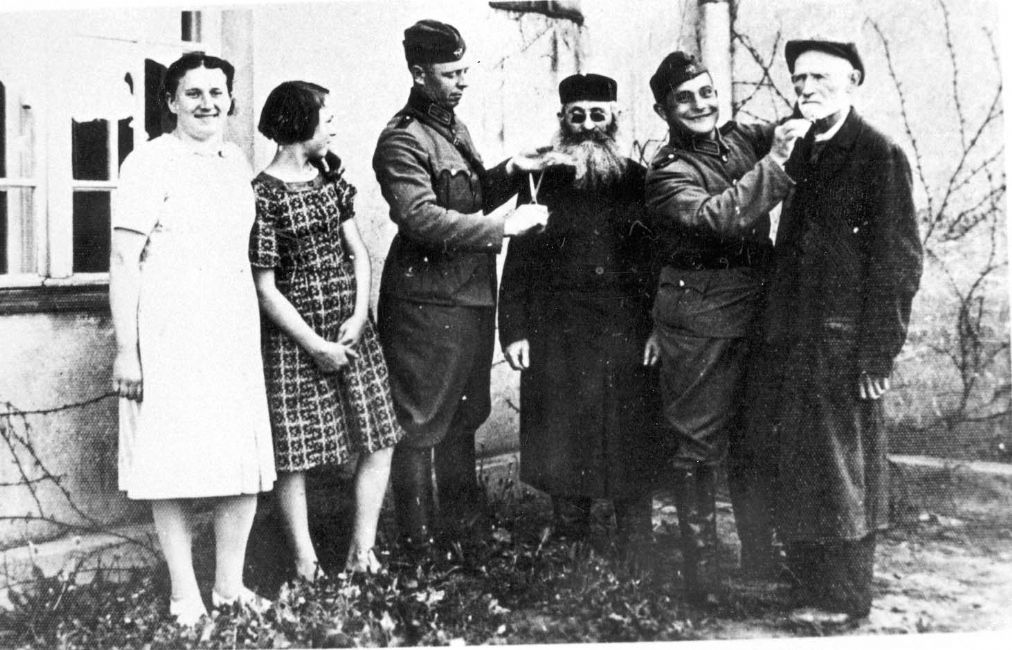 Poland ,Praszka, התעללות, שוטרים גרמנים גוזרים זקנים של יהודים.<br>
ארכיון יד ושם, 2656/12