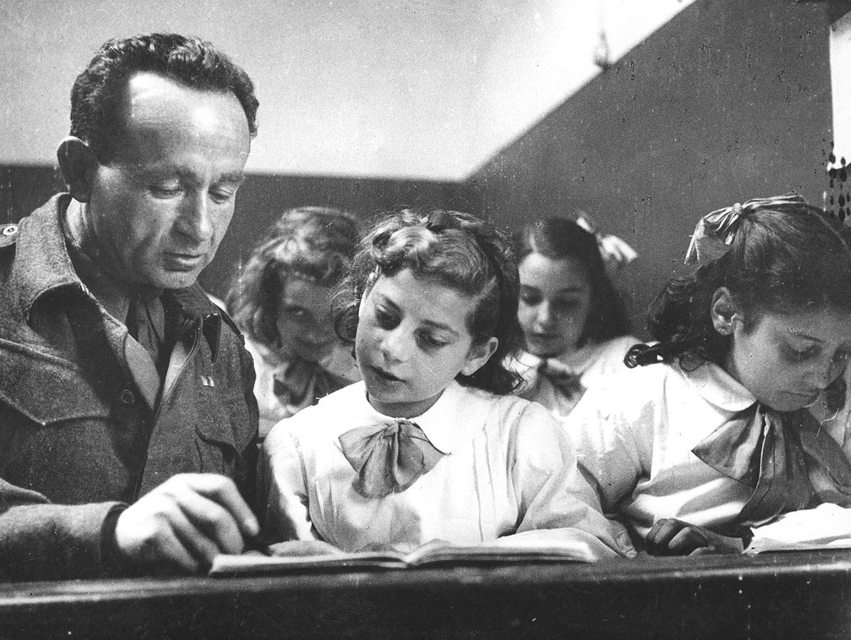 Солдат из Эрец-Исраэль (подмандатной Палестины), служащий в британской армии, учит еврейских детей ивриту в лагере в Италии после войны